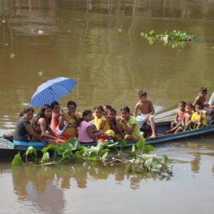 Ribeirinhos em deslocamento em pequena embarcação no rio